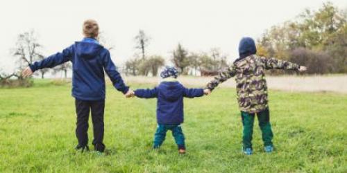 Three children holding hands with their arms out