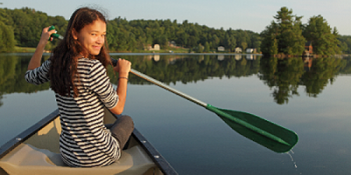 Woman with a oar on a small boat at dusk